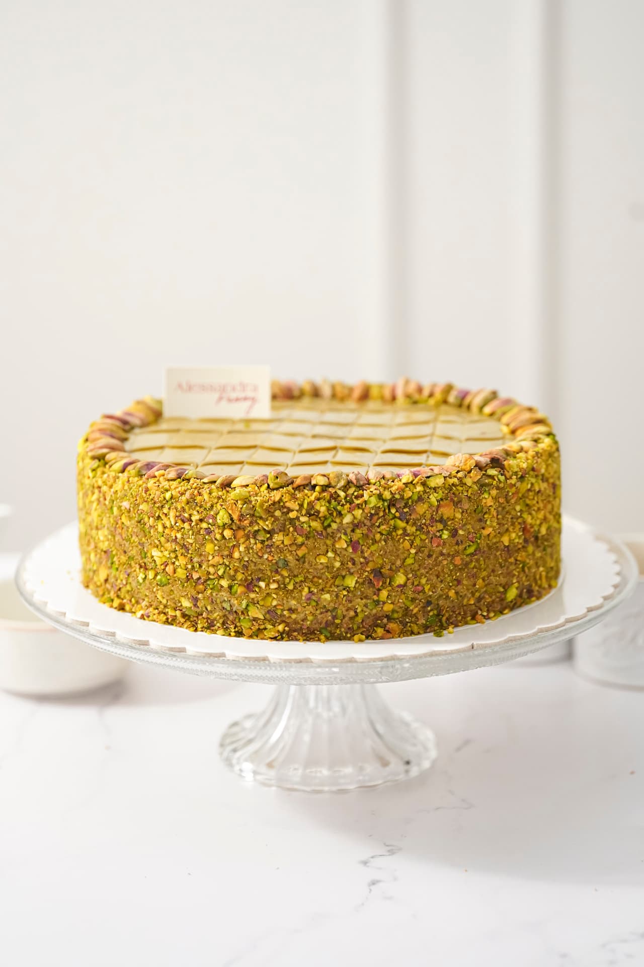 Torta Pistacho — Queque de vainilla con crema de pistacho y cobertura de pistacho.