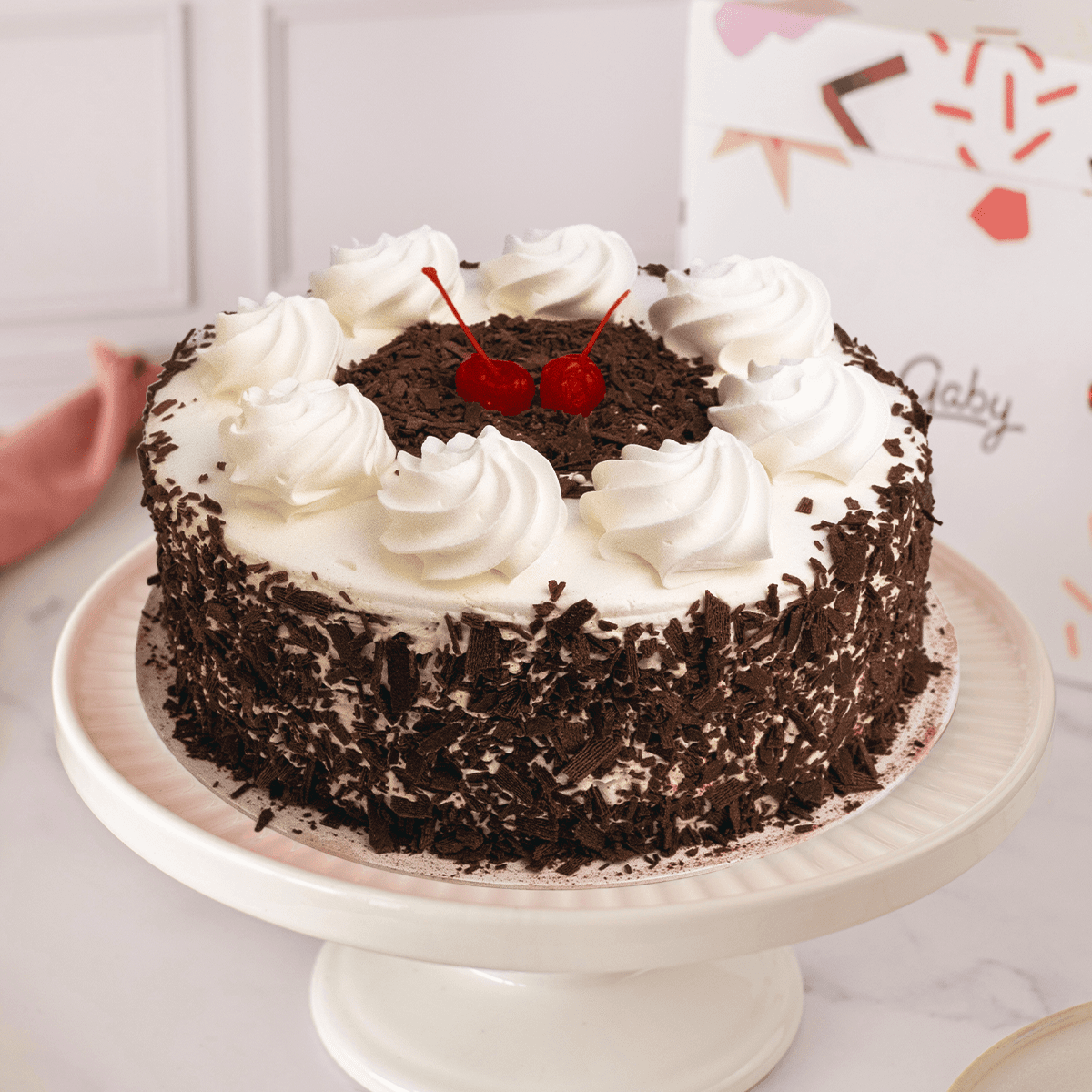 Torta Selva Negra — Queque de chocolate con cerezas, crema chantilly, virutas de chocolate y rellena de mermelada de fresa.